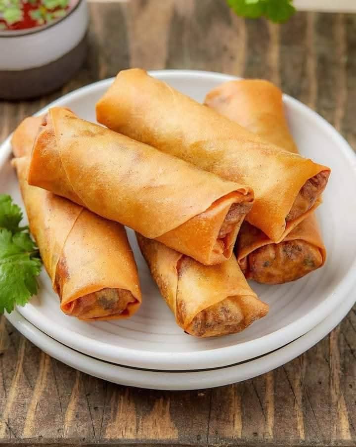 Plate of crispy spring rolls with dipping sauce
