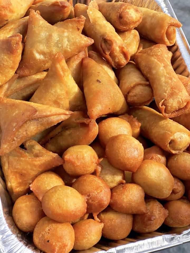 Tray of samosas, spring rolls and puff puff